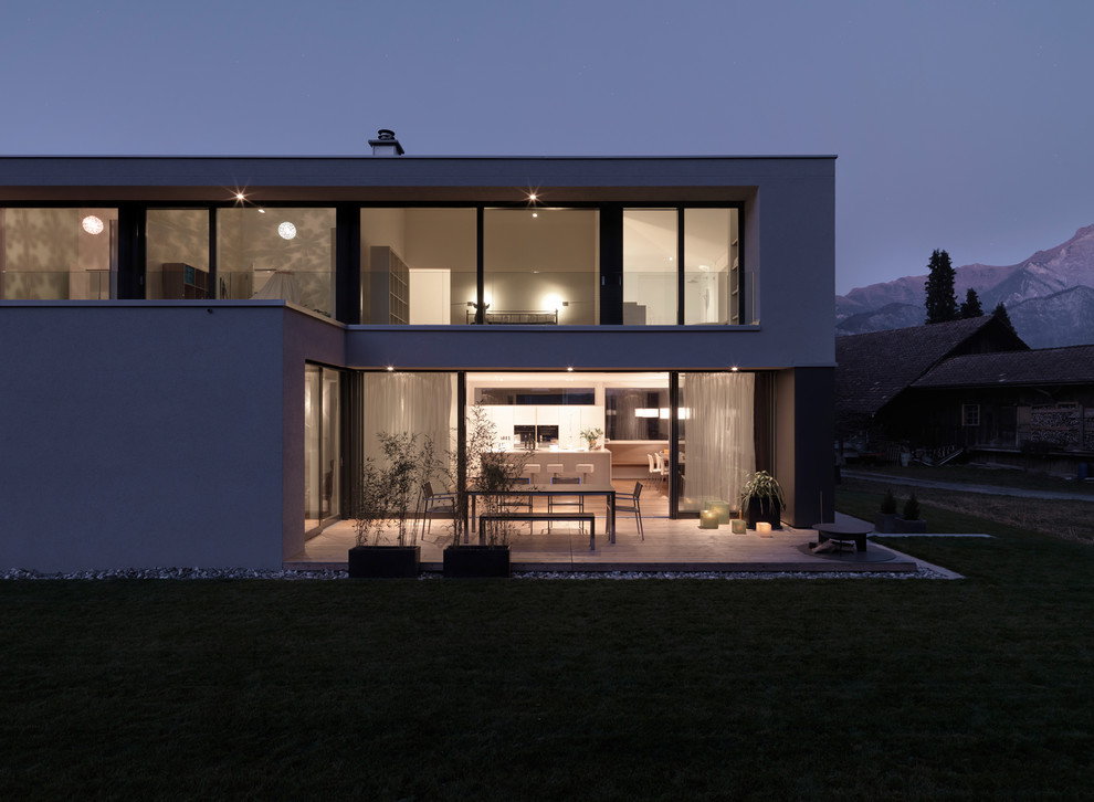 Стильный дизайн: двухэтажный дом среднего размера в стиле модернизм с плоской крышей - последний тренд
