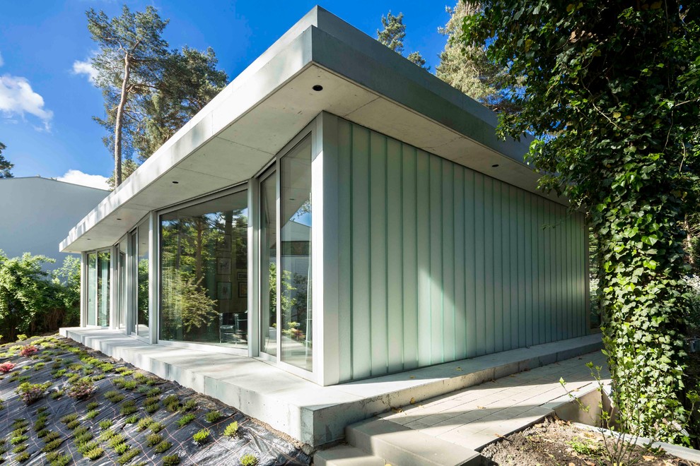 Réalisation d'une petite façade de maison design en verre de plain-pied avec un toit plat.