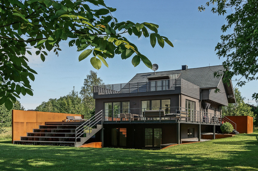 На фото: двухэтажный, деревянный, серый частный загородный дом среднего размера в современном стиле с двускатной крышей и черепичной крышей с