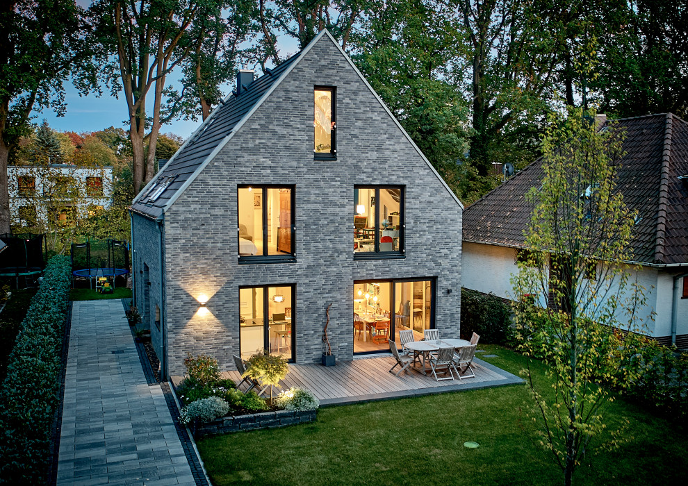 Foto de fachada de casa contemporánea de tamaño medio de una planta con revestimiento de ladrillo, tejado a dos aguas y tejado de teja de barro