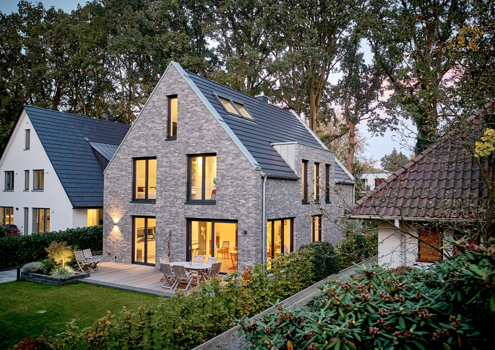 Immagine della villa piccola contemporanea a un piano con rivestimento in mattoni, tetto a capanna e copertura in tegole