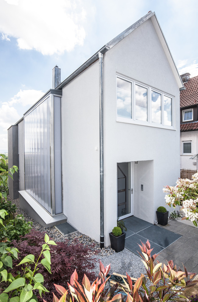 Mittelgroßes, Zweistöckiges Modernes Einfamilienhaus mit Mix-Fassade, weißer Fassadenfarbe und Satteldach in Stuttgart