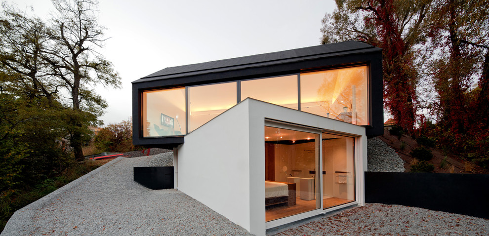 Immagine della facciata di una casa contemporanea a due piani di medie dimensioni con rivestimenti misti e tetto a capanna