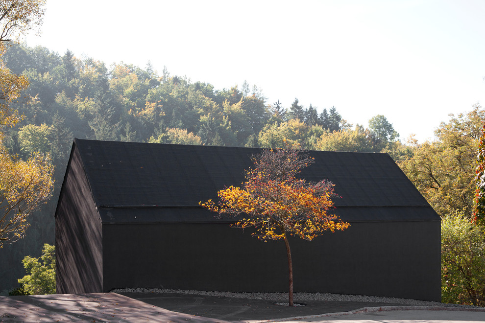 Foto della villa nera contemporanea a due piani di medie dimensioni con rivestimenti misti e tetto a capanna