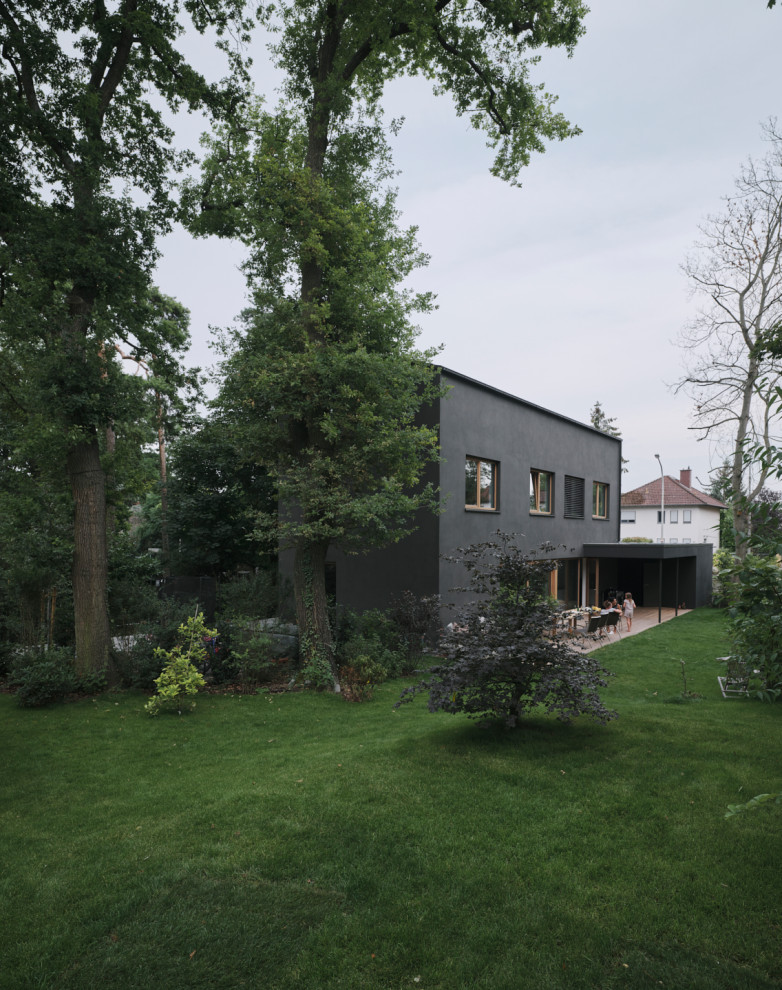 Mittelgroßes, Dreistöckiges Modernes Einfamilienhaus mit Putzfassade, schwarzer Fassadenfarbe, Satteldach und Ziegeldach in Frankfurt am Main