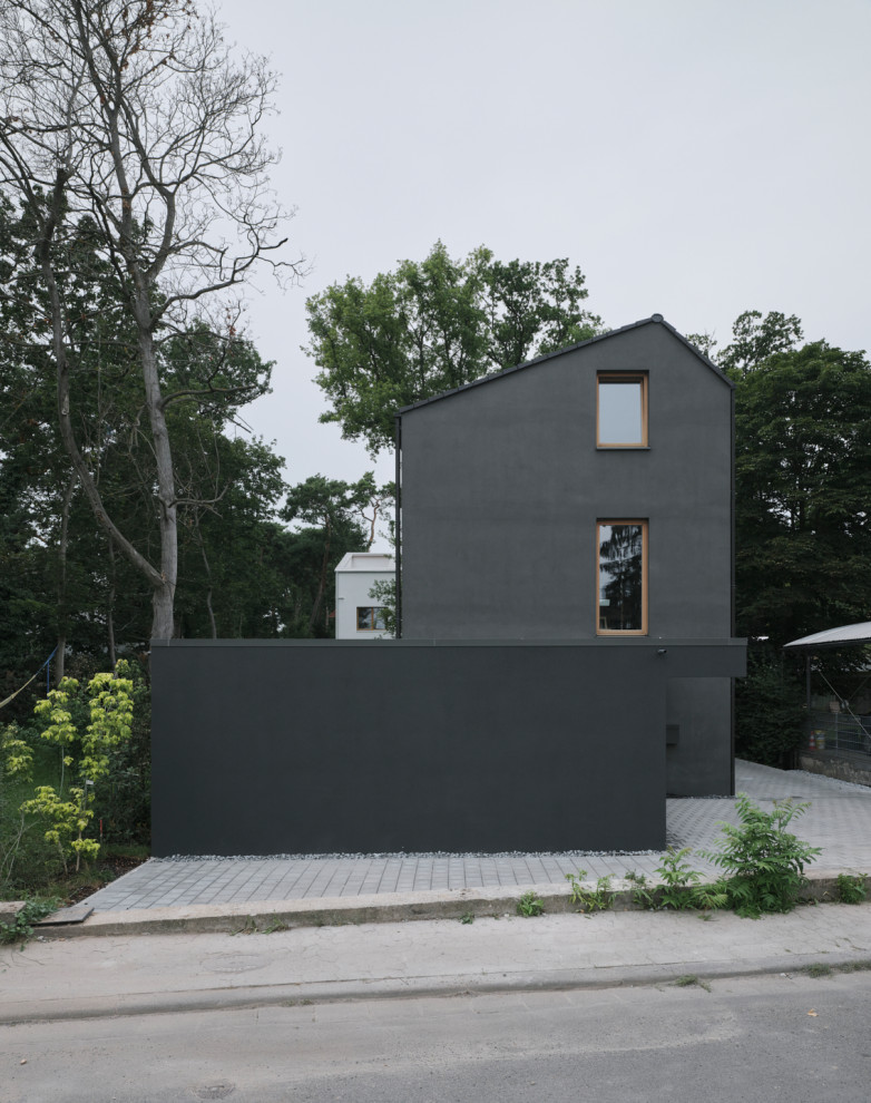 Ispirazione per la villa nera moderna a tre piani di medie dimensioni con rivestimento in stucco, tetto a capanna e copertura in tegole