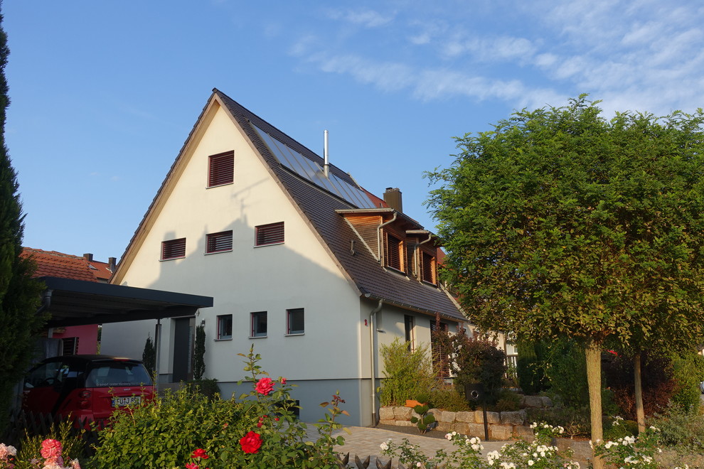 Aménagement d'une petite façade de maison mitoyenne beige contemporaine en stuc à un étage avec un toit à deux pans et un toit en tuile.