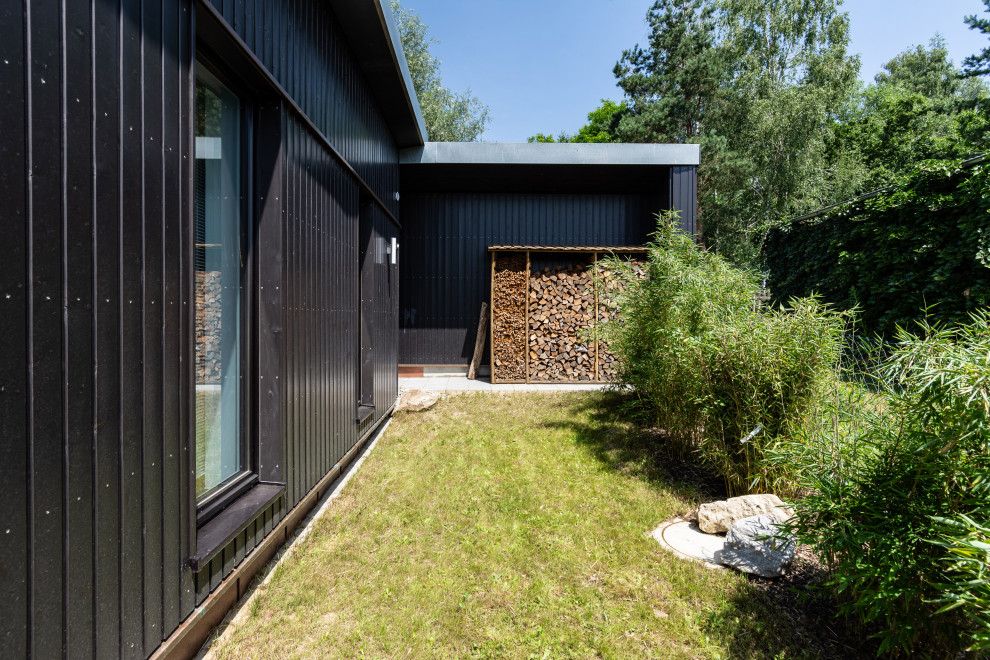 Kleines, Zweistöckiges Modernes Haus mit schwarzer Fassadenfarbe, Pultdach und Blechdach in München