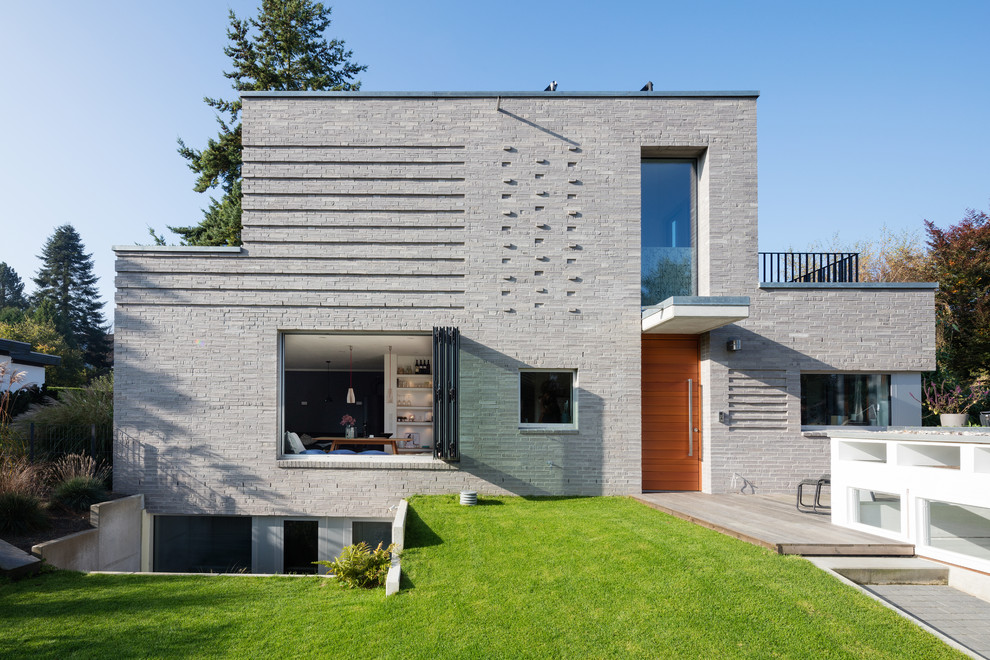 Zweistöckiges Modernes Einfamilienhaus mit Steinfassade, grauer Fassadenfarbe und Flachdach in Hamburg