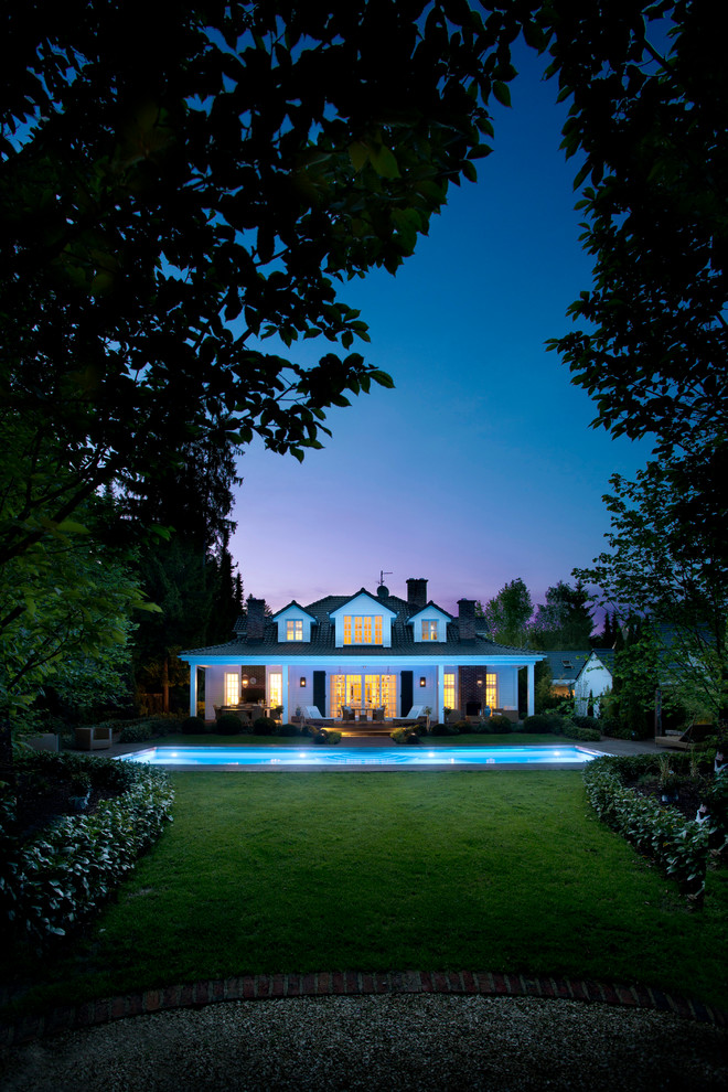 Island style white wood exterior home photo in Cologne with a hip roof