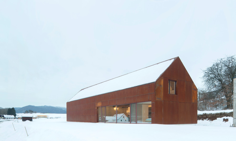 Foto de fachada de casa marrón industrial de tamaño medio de dos plantas con revestimiento de metal y tejado a dos aguas