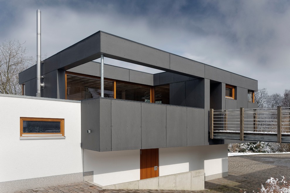 Imagen de fachada negra contemporánea de tamaño medio de dos plantas con revestimiento de aglomerado de cemento y tejado plano