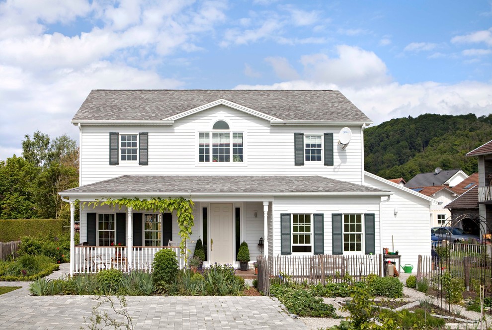 Aménagement d'une façade de maison blanche campagne de taille moyenne et à un étage avec un toit à deux pans.