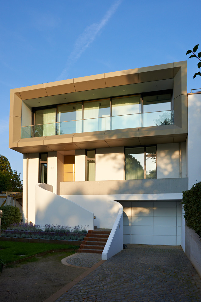 Immagine della facciata di una casa bianca contemporanea a due piani con rivestimento in metallo