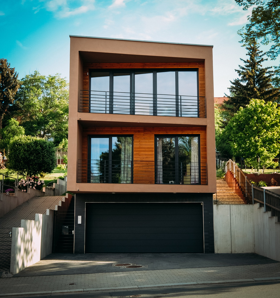 Стильный дизайн: двухэтажный, коричневый частный загородный дом среднего размера в современном стиле с облицовкой из цементной штукатурки и плоской крышей - последний тренд
