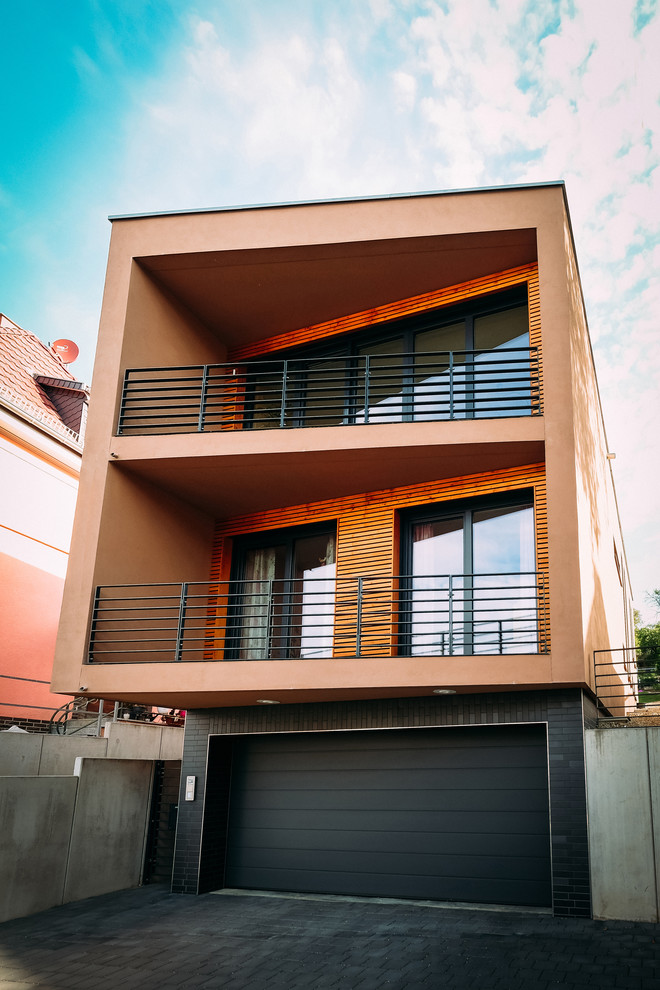 Diseño de fachada de casa marrón moderna de tamaño medio de dos plantas con revestimiento de estuco y tejado plano