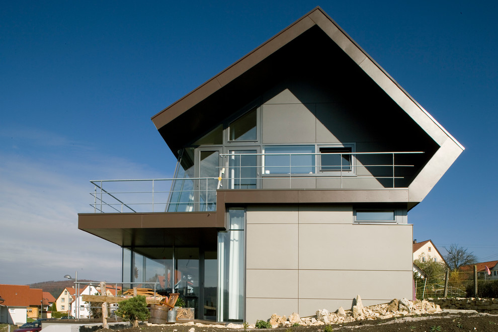 Idee per la facciata di una casa grigia contemporanea a piani sfalsati di medie dimensioni con rivestimento in metallo