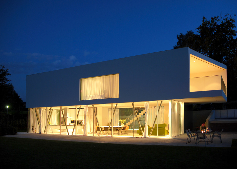 На фото: двухэтажный, белый дом среднего размера в современном стиле с комбинированной облицовкой и плоской крышей с