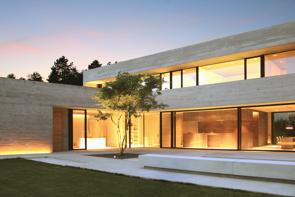 Ejemplo de fachada de casa beige minimalista grande de dos plantas con tejado plano y revestimiento de hormigón