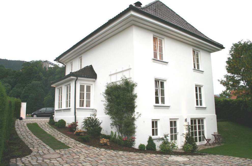 Inspiration for a medium sized and white contemporary two floor house exterior in Munich with stone cladding.