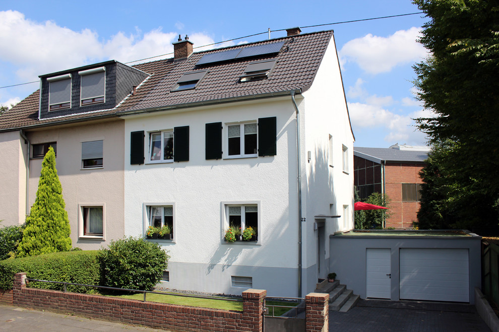 Zweistöckige Klassische Doppelhaushälfte mit Putzfassade, weißer Fassadenfarbe, Satteldach und Ziegeldach in Köln