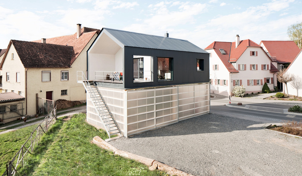 Aménagement d'une façade de maison container grise contemporaine à un étage et de taille moyenne avec un revêtement mixte et un toit à deux pans.