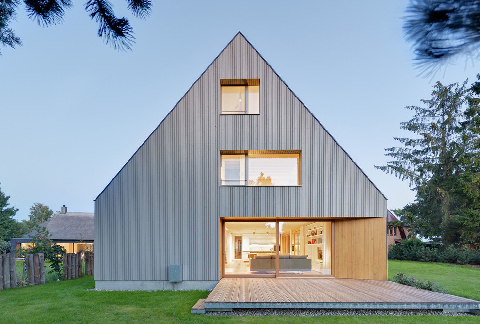 Inspiration för mellanstora moderna grå trähus, med tre eller fler plan och sadeltak