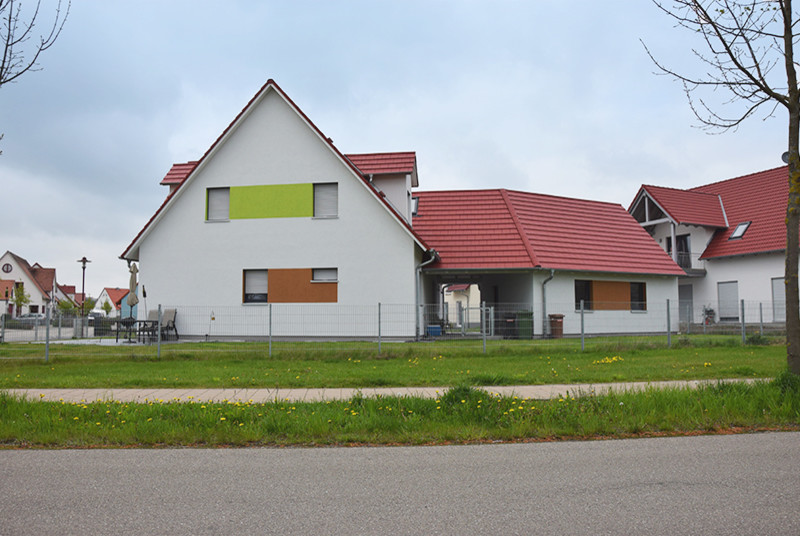 Large and multi-coloured classic two floor render detached house in Nuremberg with a pitched roof and a tiled roof.