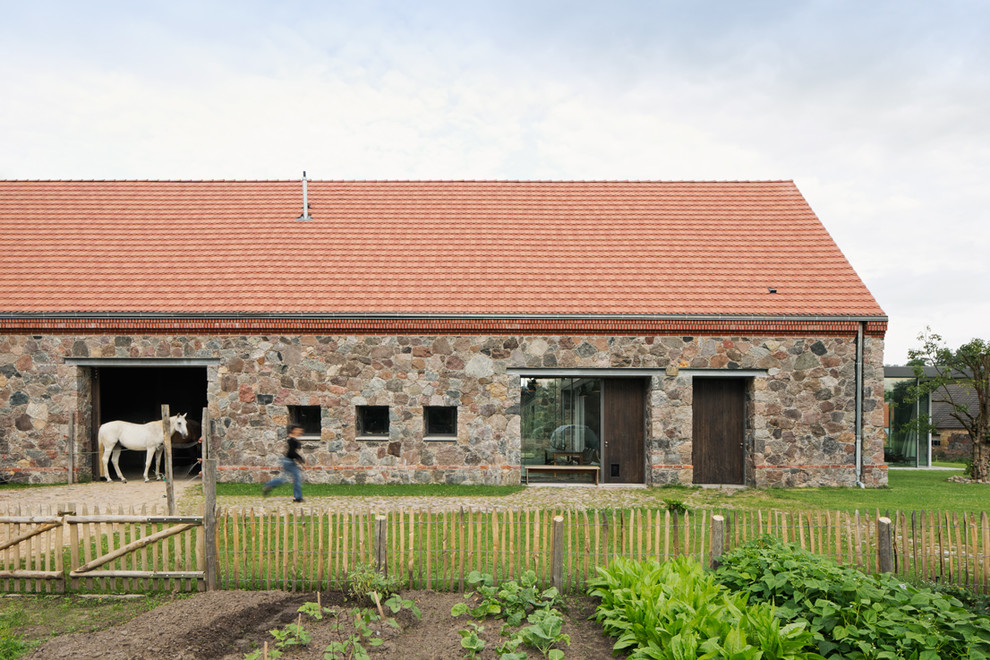 Idee per la facciata di una casa marrone country a due piani di medie dimensioni con rivestimento in pietra e tetto a capanna