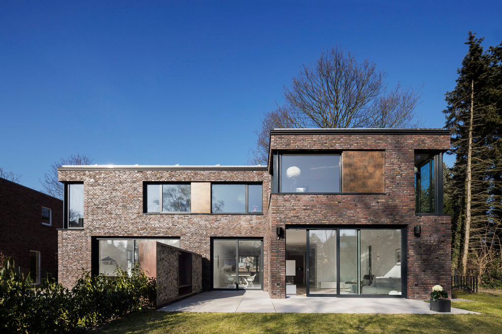 Modelo de fachada de casa marrón contemporánea de tamaño medio de dos plantas con revestimiento de ladrillo y tejado plano