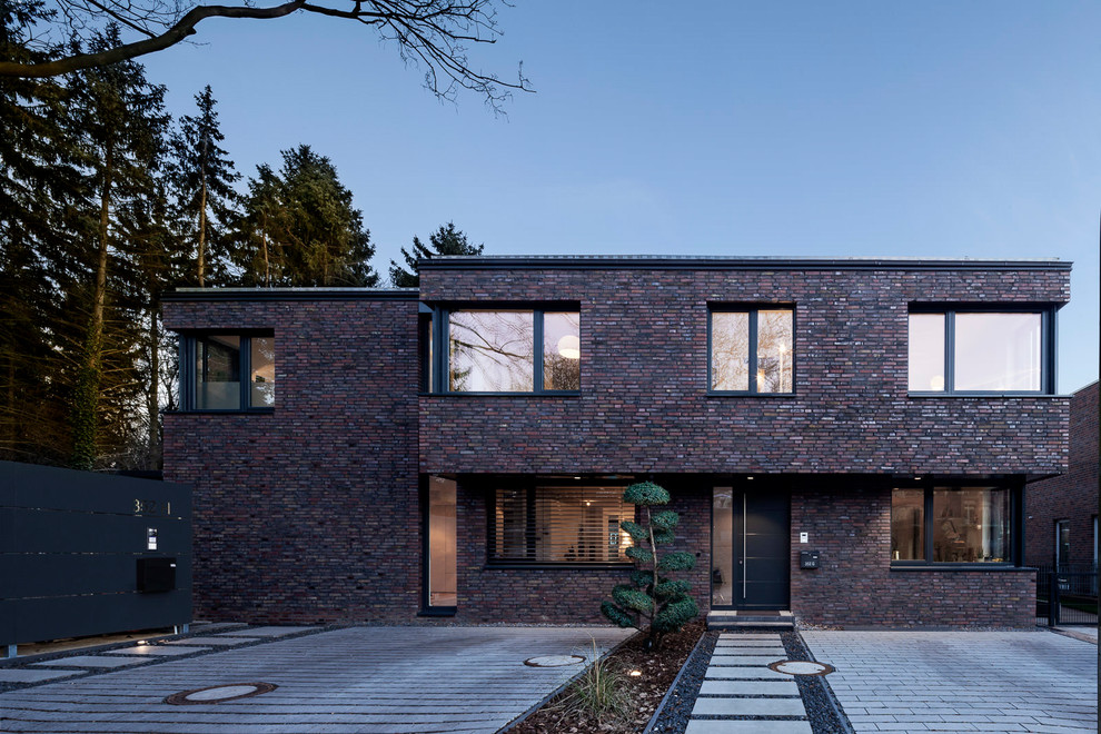 Multi-coloured and medium sized contemporary two floor detached house in Hamburg with stone cladding, a flat roof and a metal roof.