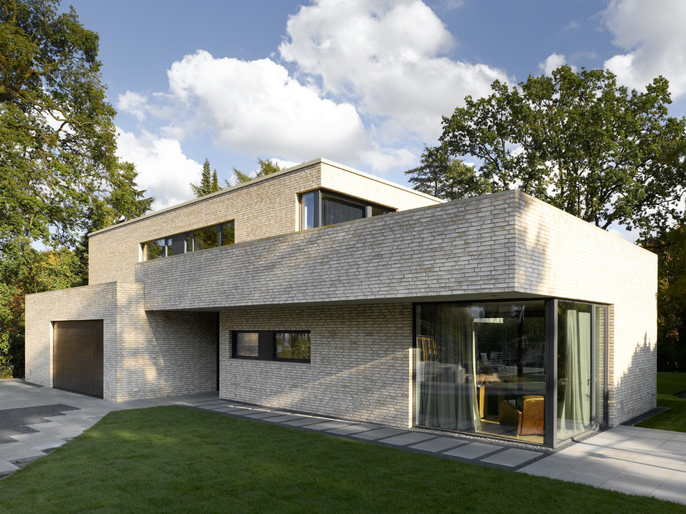 Свежая идея для дизайна: двухэтажный, кирпичный, бежевый дом среднего размера в стиле модернизм с плоской крышей - отличное фото интерьера