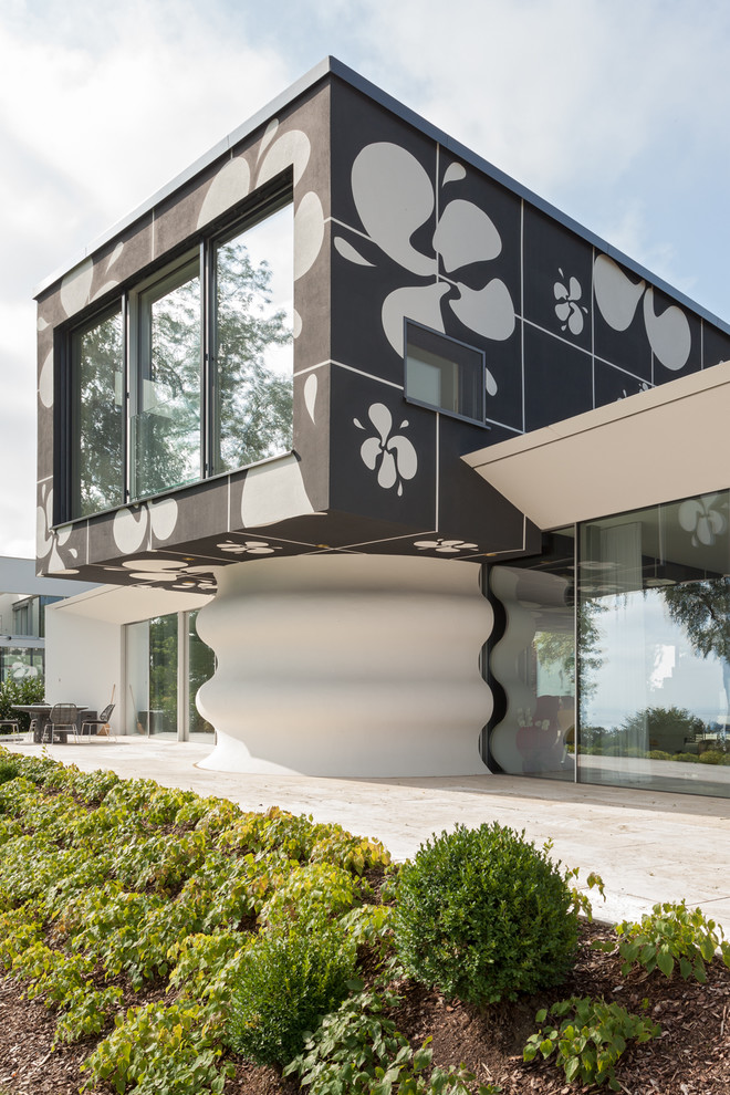 Aménagement d'une façade de maison multicolore contemporaine à un étage avec un revêtement mixte et un toit plat.