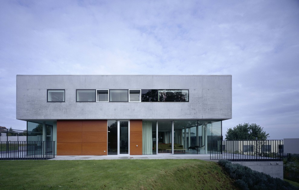 Стильный дизайн: большой, двухэтажный, серый дом в стиле модернизм с облицовкой из бетона и плоской крышей - последний тренд
