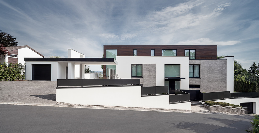 Großes, Dreistöckiges Modernes Haus mit Mix-Fassade, weißer Fassadenfarbe und Flachdach in Köln