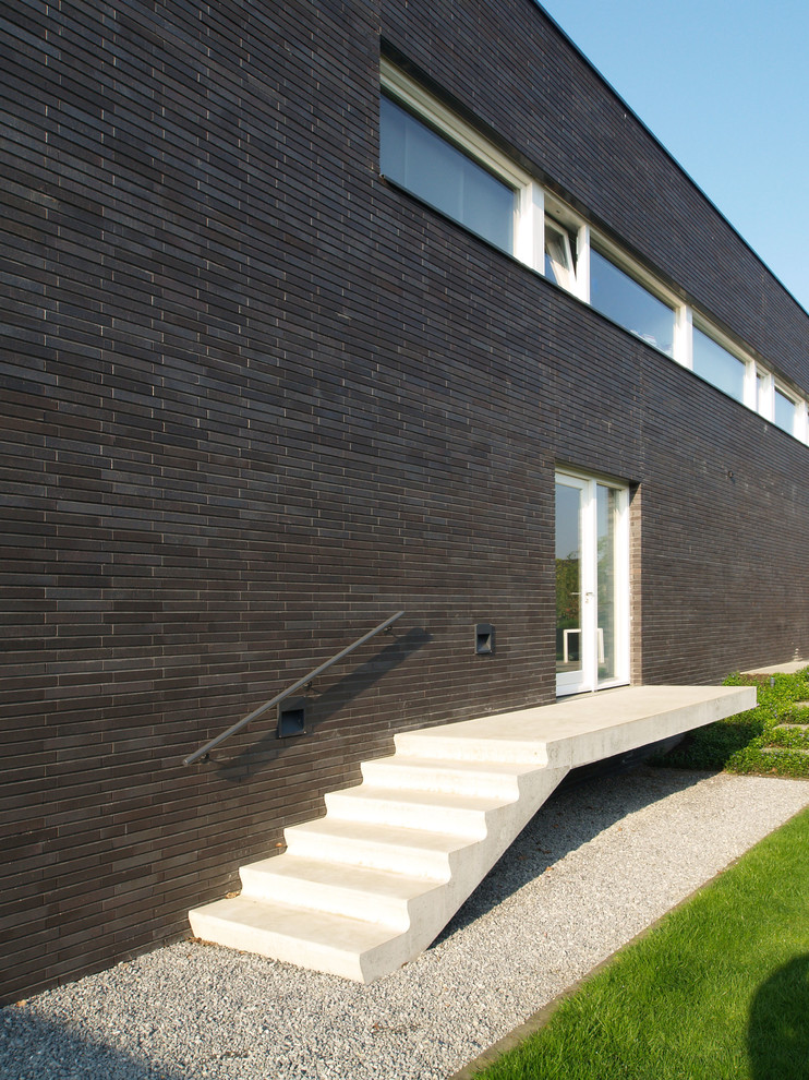 Esempio della facciata di una casa grande marrone contemporanea con rivestimento in mattoni e tetto piano