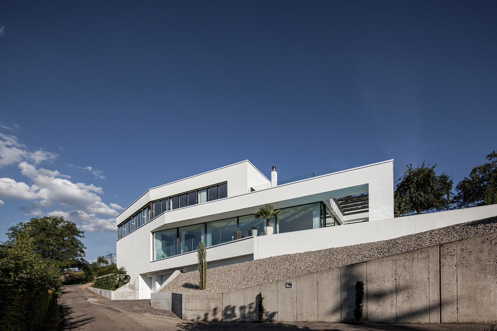 Diseño de fachada de casa blanca moderna extra grande de tres plantas con revestimiento de estuco y tejado plano