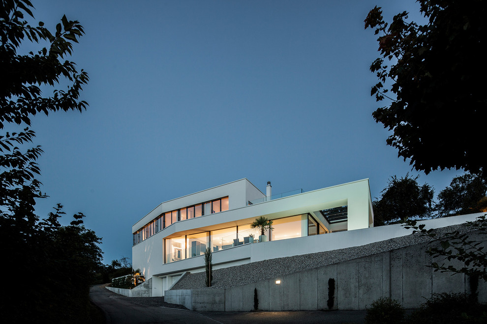 Geräumiges, Dreistöckiges Modernes Einfamilienhaus mit Putzfassade, weißer Fassadenfarbe und Flachdach in Sonstige