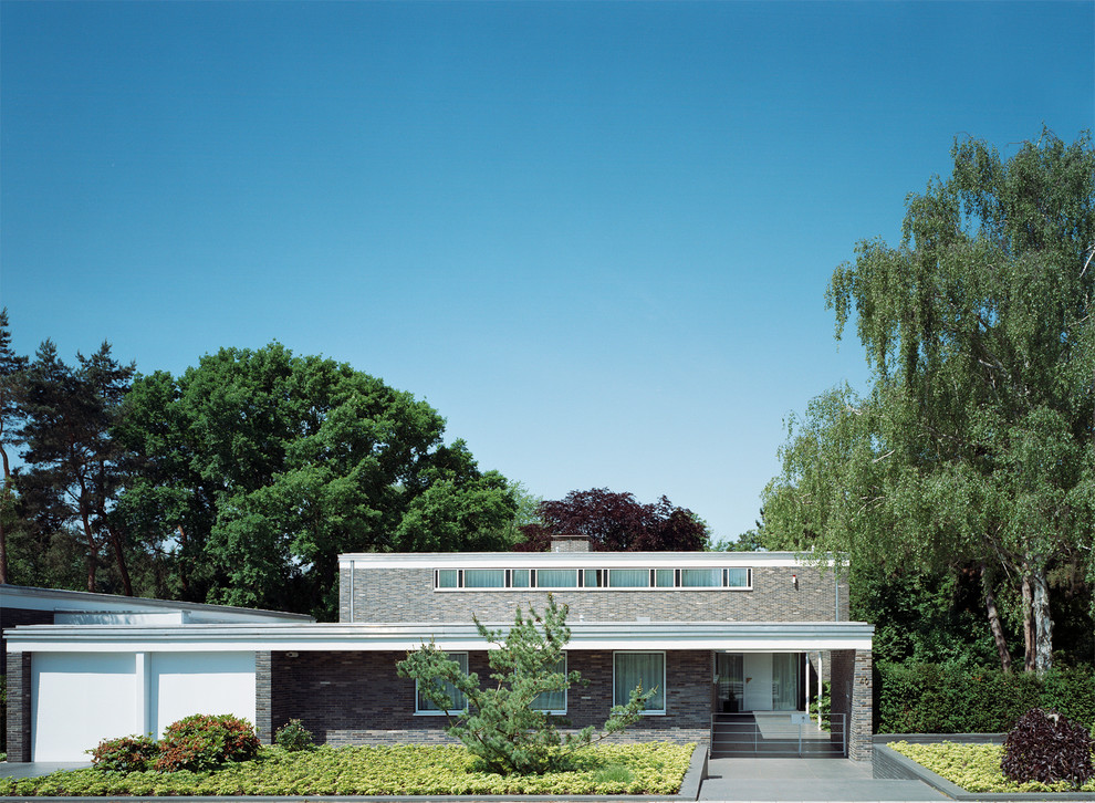 Foto de fachada gris actual de tamaño medio de dos plantas con revestimiento de ladrillo y tejado plano