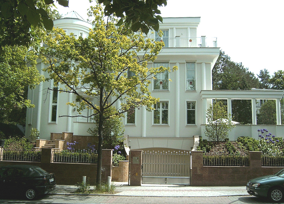 Dreistöckiges, Mittelgroßes Klassisches Haus mit Putzfassade, beiger Fassadenfarbe und Flachdach in Berlin