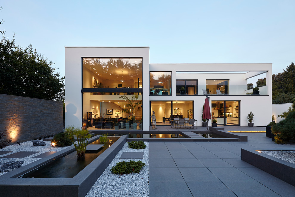 Geräumiges, Zweistöckiges Asiatisches Haus mit Betonfassade, weißer Fassadenfarbe und Flachdach in Düsseldorf