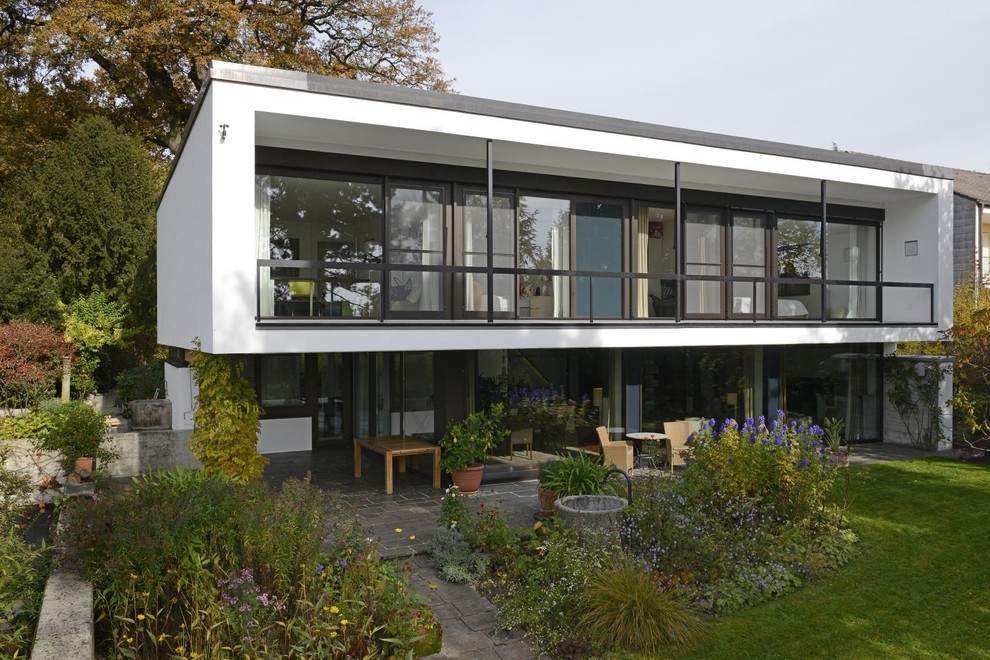 Свежая идея для дизайна: двухэтажный, белый дом среднего размера в стиле модернизм с односкатной крышей - отличное фото интерьера