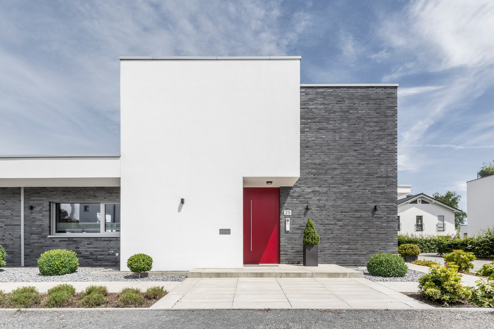 Imagen de fachada blanca minimalista extra grande de dos plantas con revestimiento de hormigón y tejado plano