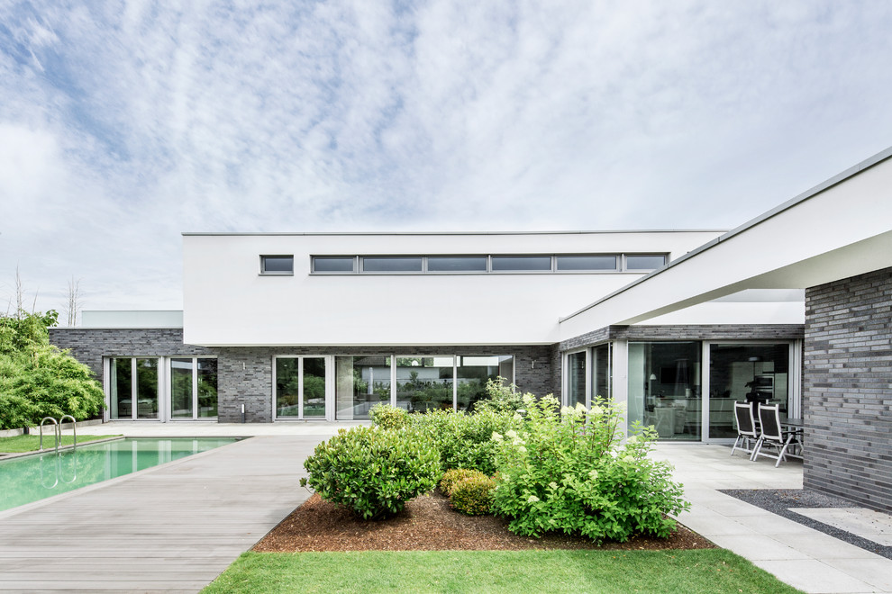 Large minimalist gray two-story mixed siding flat roof photo in Dusseldorf