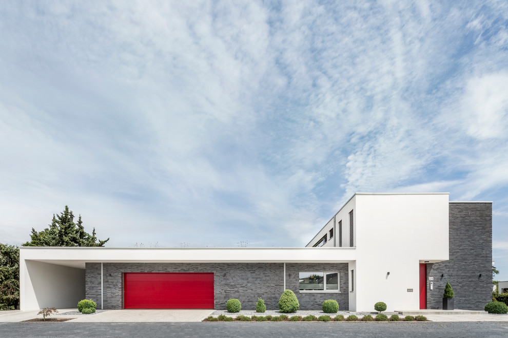 На фото: огромный, двухэтажный, белый дом в стиле модернизм с облицовкой из бетона и плоской крышей с