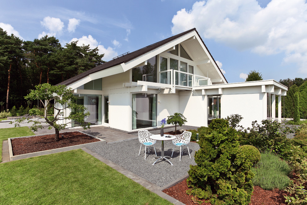 Photo of a white and medium sized contemporary two floor render house exterior in Other with a pitched roof.