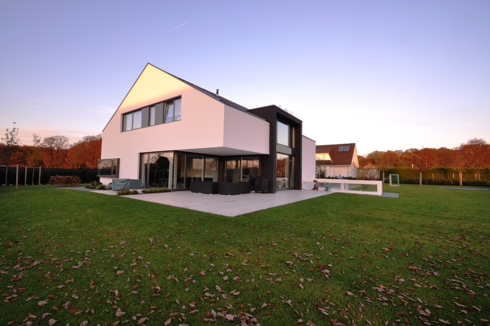Geräumiges Modernes Einfamilienhaus mit Putzfassade, weißer Fassadenfarbe, Satteldach und Ziegeldach in Düsseldorf