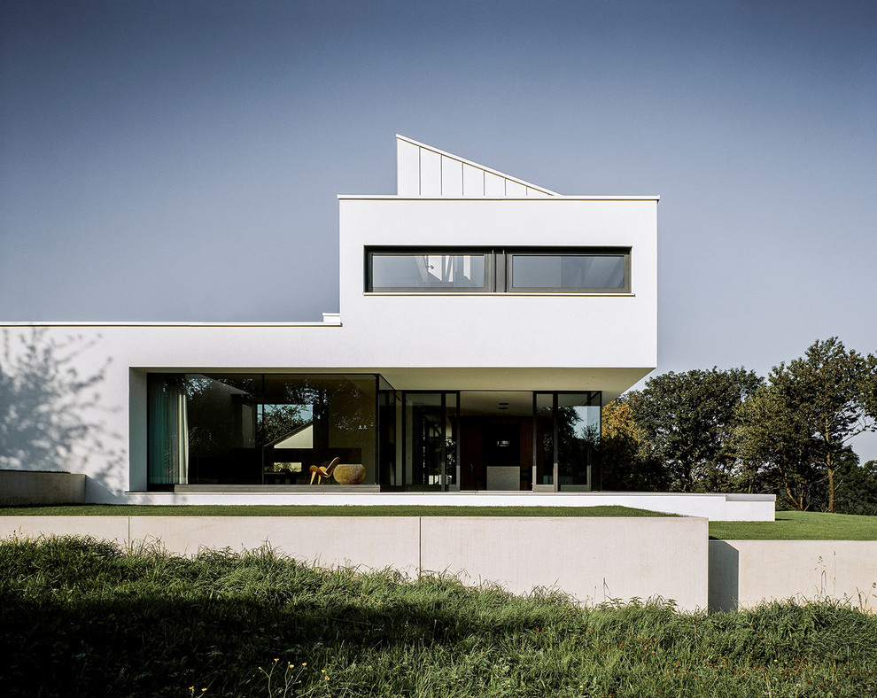 Geräumiges, Dreistöckiges Modernes Einfamilienhaus mit Putzfassade, weißer Fassadenfarbe und Flachdach in Stuttgart
