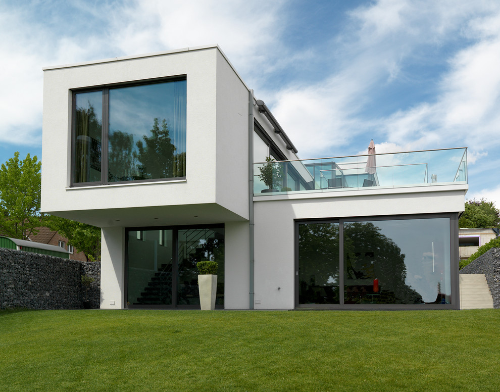 Идея дизайна: белый, двухэтажный дом среднего размера в стиле модернизм с плоской крышей
