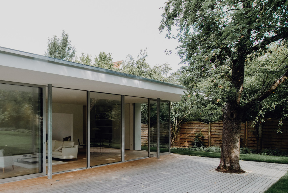 Ejemplo de fachada de casa blanca minimalista extra grande de dos plantas con revestimiento de madera, tejado plano y tejado de metal